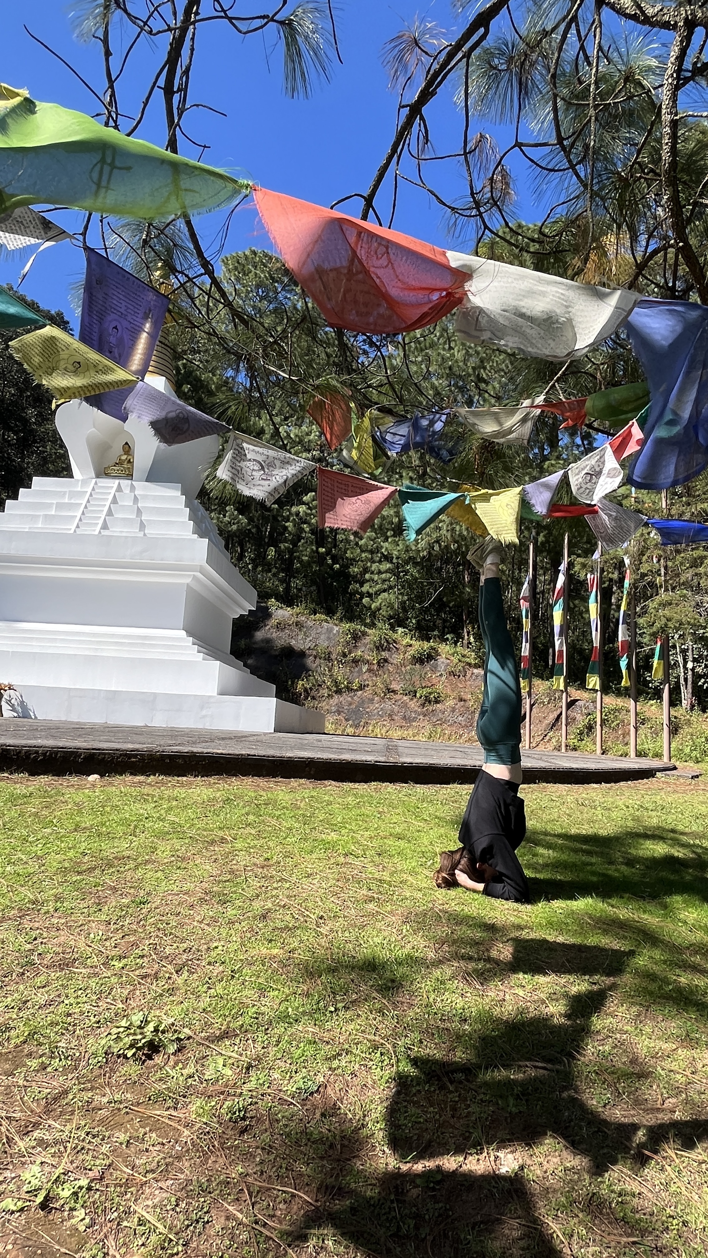 Kristen in a headstand among prayer flags